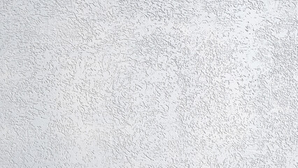 Aufkleber - A white wall with a rough texture. The wall is covered in small white dots. The wall appears to be unfinished and unfinished