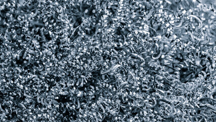 Aufkleber - A pile of metal shavings with a metallic sheen. The shavings are scattered and appear to be from a grinding process