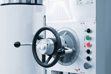 Poster - A machine with a black and silver handle with a white and black knob. The knob is labeled with numbers and buttons