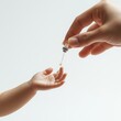 © Irina Kozel - A child's hand reaches out to receive a drop of insulin from a parent's hand in a soft-focused, tender moment