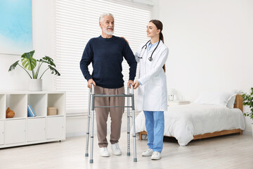 Wall Mural - Doctor helping senior man with walking frame in clinic