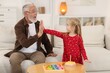 © New Africa - Grandpa and his granddaughter giving five at home