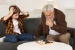 © New Africa - Grandpa and his grandson playing checkers at table indoors