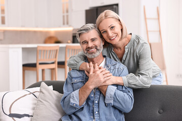 Wall Mural - Portrait of happy middle aged couple in kitchen