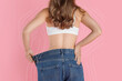 © New Africa - Woman in big jeans showing her slim body on pink background, closeup. Back view. Lines around repeating her figure