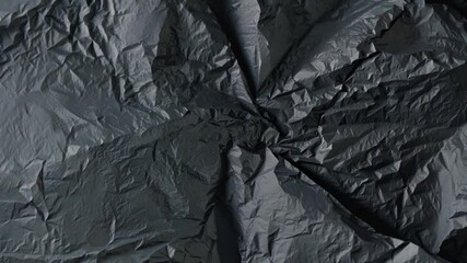 Poster - A deep black textured surface created from crumpled paper reveals intricate creases and shadows, perfect for creative projects or a striking backdrop.