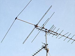 Old outdated analog TV antenna on the roof of the house