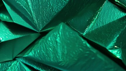 Leinwandbilder - A close-up view of shiny emerald-green foil featuring complex folds and creases under bright light, creating a vivid texture. The reflections add depth and dimension to the scene.
