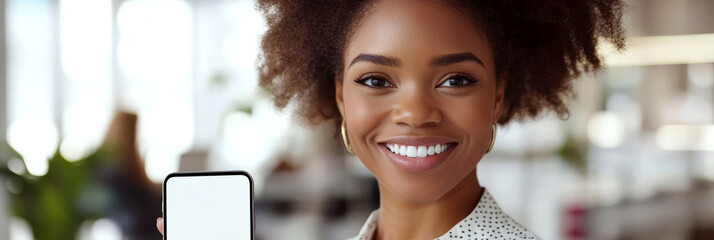 Young woman indoors holding a smartphone with a blank screen, smiling. Concept of positivity and technology. For social media or mobile app promotions.