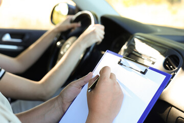 Driving school. Student passing driving test with examiner in car, closeup