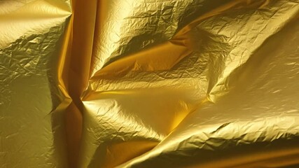 Poster - A luxurious golden fabric is artfully draped, reflecting light and showcasing its rich texture and depth. The folds create an alluring visual display, inviting closer inspection.