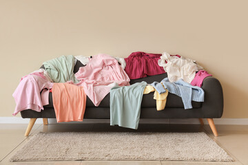 Scattered female clothes on sofa near color wall