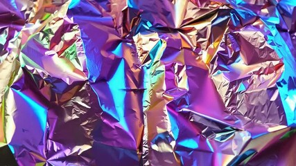 Poster - Brightly colored metallic foil creates a dynamic texture that captures and reflects light in various angles, showcasing a shimmering, abstract pattern.