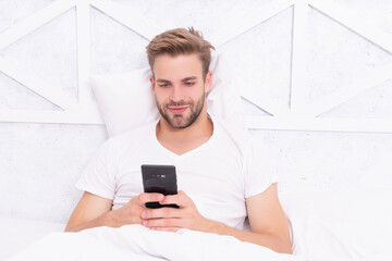 Morning chat. Man read message in bedroom. Browsing social media. Online shopping. Millennial man use smartphone in bed at home. Man chat on smartphone. Message chatting online. Chatting with Friends