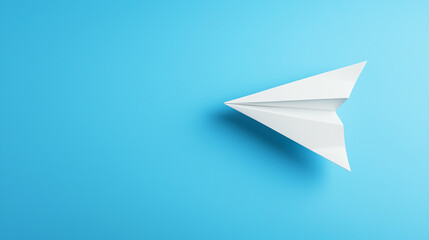 White paper airplane flying on a blue background. Minimalist concept of travel, freedom, and hope.