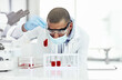 © peopleimages.com - Man, scientist and blood sample at laboratory with vial, face mask and study for mpox vaccine trial. Person, liquid and container with thinking, ppe and safety with chemical for medical research