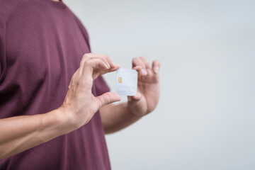 Wall Mural - Close-up of a man's hand holding a bank credit card, highlighting online services for lending and access to credit,demonstrating financial convenience and flexibility for secure digital transactions