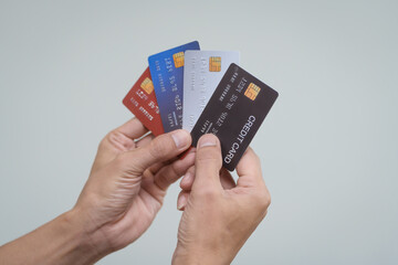 A close-up of a man’s hand holding a bank credit card against a white background, emphasizing secure online payment services and financial convenience for shopping and banking transactions