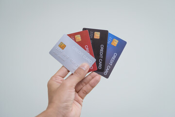 Wall Mural - A close-up of a man’s hand holding a bank credit card against a white background, emphasizing secure online payment services and financial convenience for shopping and banking transactions