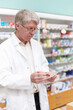 © peopleimages.com - Man, reading and pharmacist with prescription at dispensary for medication, supplements or pills. Chemist, inventory and senior male apothecary with stock list for medicine or tablets in drug store.