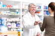 © peopleimages.com - Pharmacist, customer and smile for wellness, help and medicine in drugstore, chemist or pharmacy. Medical professional, male person and sales for prescription or info in dispensary as advice or care