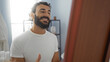 © Krakenimages.com - Handsome young hispanic man smiling in a wellness center spa room with a beard and a relaxed expression