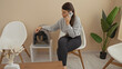 © Krakenimages.com - A young hispanic woman in a veterinary clinic waiting room tends to her pet kitten in a carrier while talking on a phone.