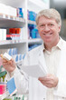 © peopleimages.com - Man, pharmacist and happy with prescription for medication, pills and box for healthcare at drugstore. Mature person, portrait and smile at pharmacy with checklist for product, medicine and treatment