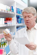 © peopleimages.com - Man, pharmacist and reading prescription for medication, pills and drug store with box for healthcare. Mature person, shelf and pharmacy with checklist for product, medicine and treatment or stock