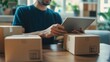 © STGZ. - Entrepreneur managing e-commerce orders on a tablet while sitting in a home office
