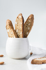 Wall Mural - almond biscotti in a white cup, almond cantucci cookies in a ceramic mug