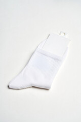 White socks with blank label on a white background with copy space, close-up. New cotton socks