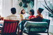 © BullRun - Group of delighted multiethnic friends chatting at home