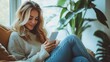 © PhotoStar - A woman in jeans sitting indoors and using her smartphone