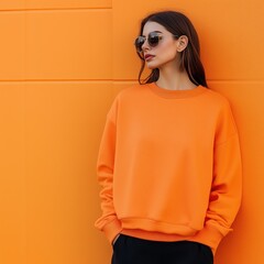 Women's basic sweatshirt mockup. Beautiful young woman model in orangeGildan 18000, standing against colorful bright wall background. Women's crewneck long sleeve tshirt mockup. Blank shirt template	
