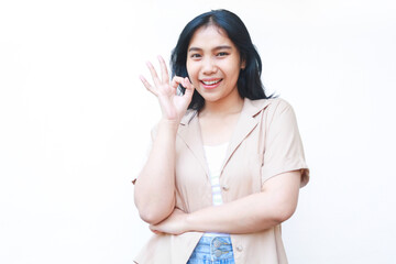 satisfied asian woman showing okay signs with excitement wearing casual brown clothes isolated on white background