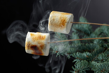 Toasted marshmallows on the background of a Christmas tree.