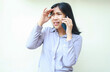 © M Alfan Setyawan - portrait of confused asian young business woman look away worried while having conversation on smartphone, isolated over white background female touch her forehead