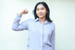 © M Alfan Setyawan - peaceful young asian business woman show strength bicep muscle with raising arm fist looking at camera with smiling relax expression, wear formal shirt, isolated on white background