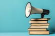© Bussakon - Megaphone Resting on a Stack of Books Symbolizing the Power of Knowledge and Communication