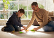 © peopleimages.com - Father, kid and play with toys at house for plastic dinosaur, learning and fantasy games of animal education. Smile, family and reptiles with creative development, bonding together and childhood fun