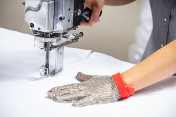 Straight knife cutter and stainless steel gloves in a clothing factory