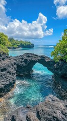 Wall Mural - A natural rock arch frames a turquoise lagoon on a tropical island.