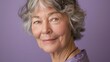 © spyrakot - Portrait of a Senior Woman with a Gentle Smile on Lavender Background