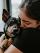 © Photo_hub - Young woman lovingly hugging her dog indoors