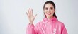 © vxnaghiyev - A young brunette woman dressed in a pink raincoat smiles and appears friendly against a white studio background holding up her hand to show the number three as she counts down. with copy space image