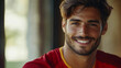 © Karina Korytchenko - Handsome Spanish football player smiling warmly while enjoying a moment indoors in natural light