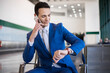 © Minerva Studio - Businessman checking time while on phone