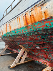 Closeup partial view of a large old wooden fishing boat on display in the harbor on the North Atlantic Ocean. Located in Nólsoy, Faroe Islands with a long history of fishing. 