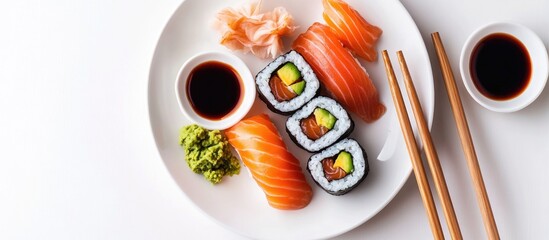 Fototapete - Sushi and maki arranged on a plate with soy sauce and chopsticks on a white background Top view with copy space